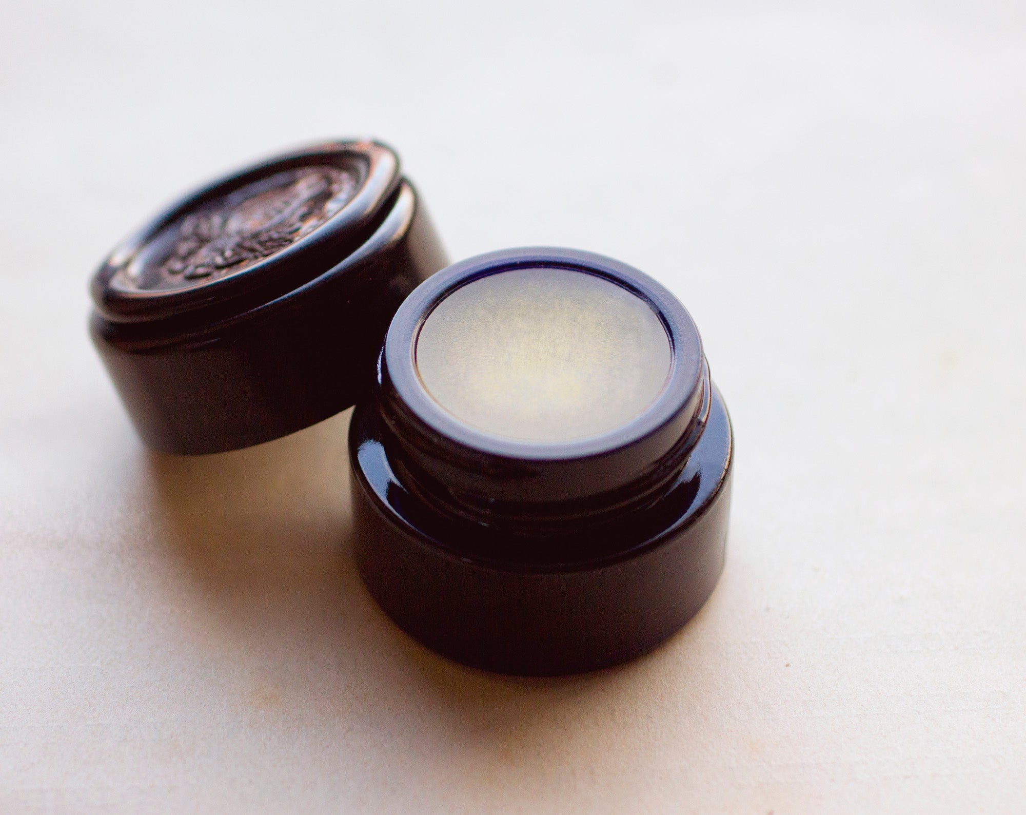 Figure 1: Noir Solid Perfume in Round Violet Jar